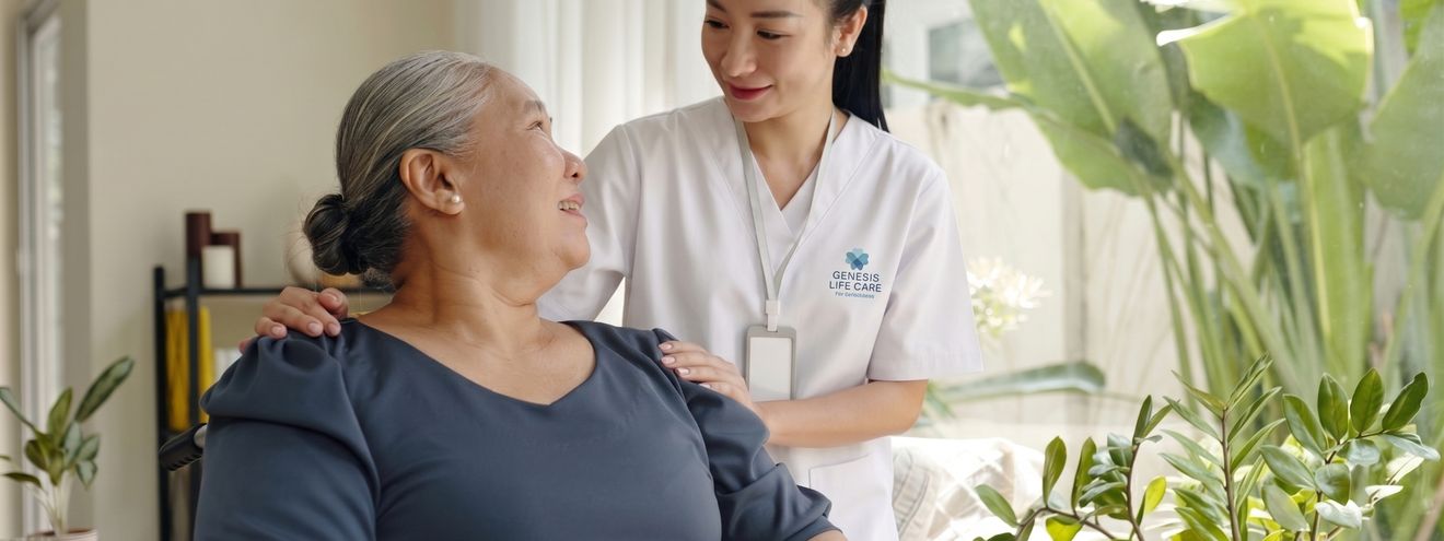 A bright memory-care lounge with a Genesis Life Care caregiver and an elderly resident